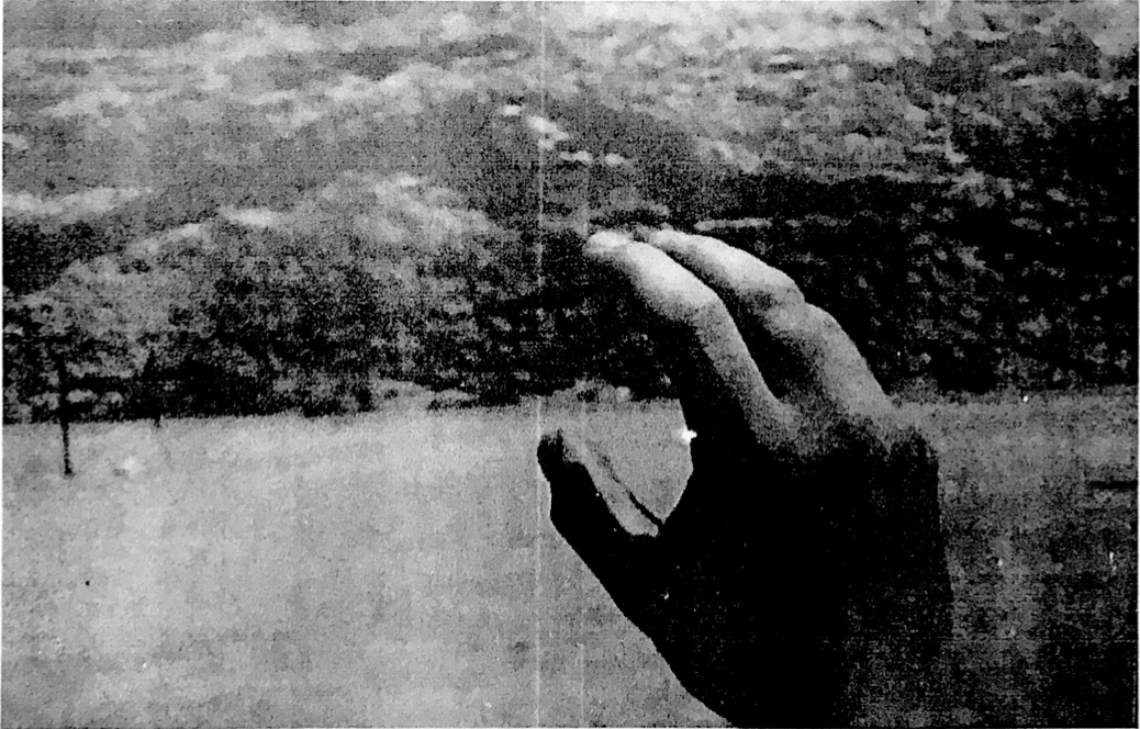 A black and white photocopied image of a man’s right hand. The hand seems to be trying to articulate something.